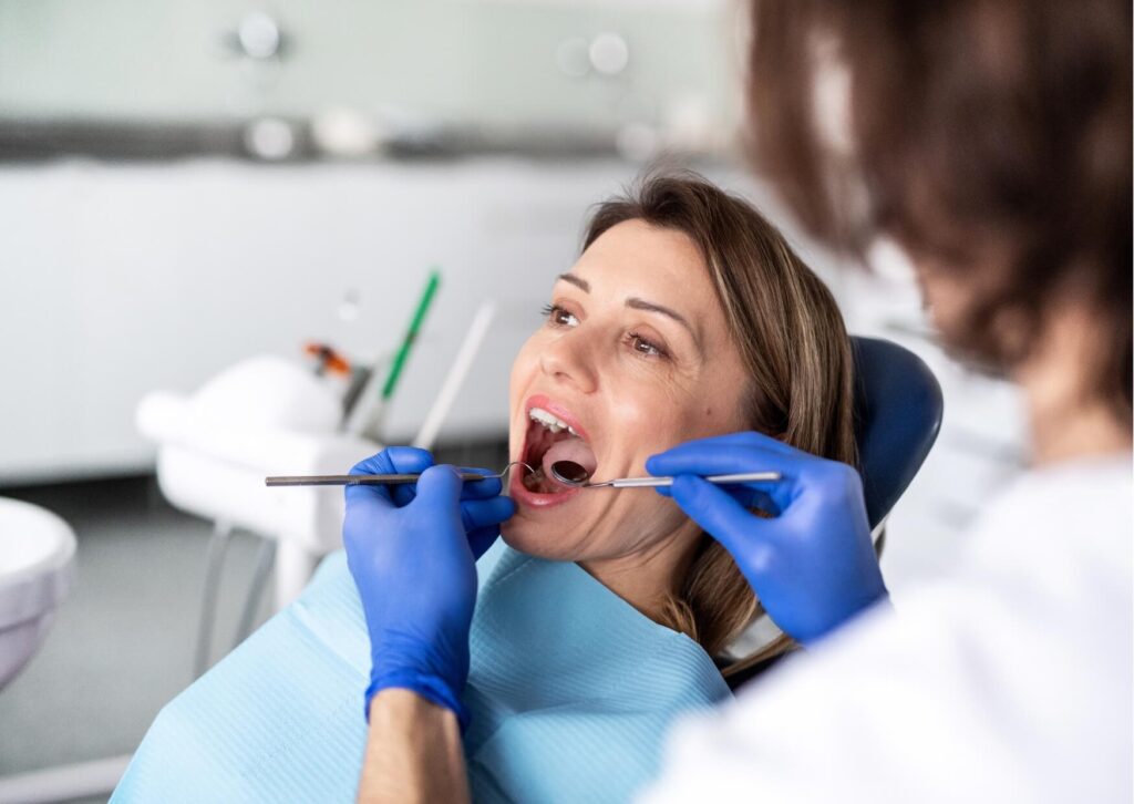 Dentist examining a patient's composite fillings during a routine checkup to monitor staining and overall condition.